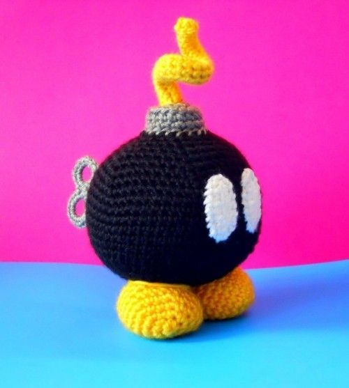 a crocheted black and white ball sitting on top of a blue surface