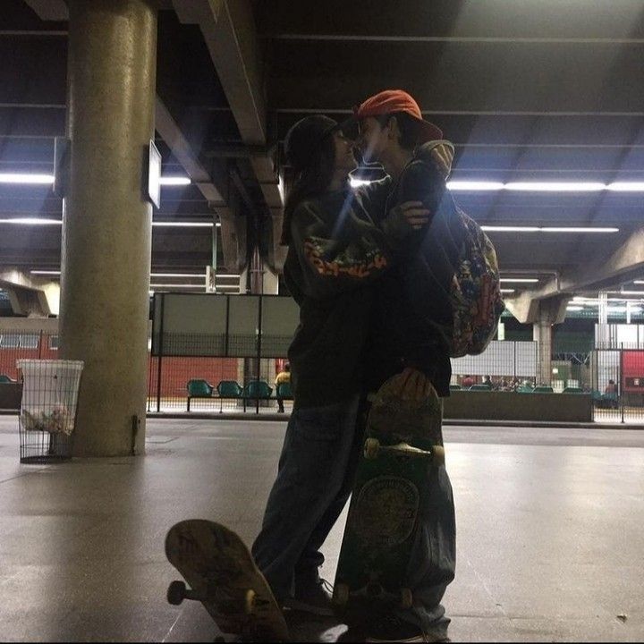 two people standing next to each other on a skateboard in an empty parking garage