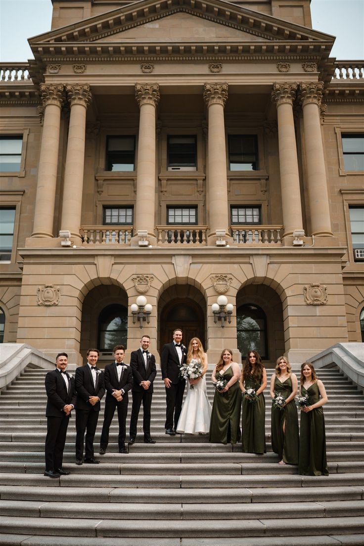 a group of people standing on steps in front of a building with columns and pillars