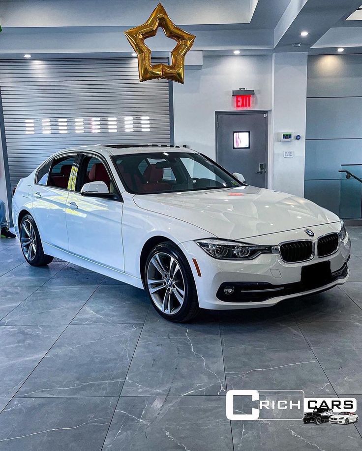 a white car parked in a garage next to a gold star hanging from the ceiling