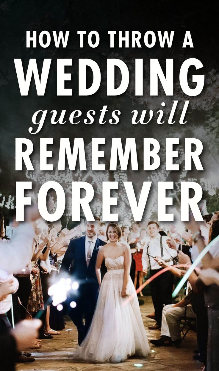 a bride and groom walking down the aisle at their wedding with fireworks in the background