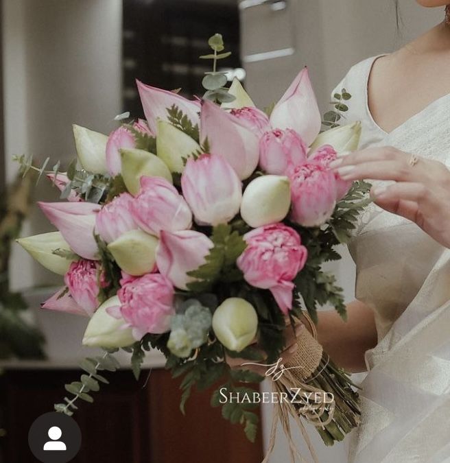 a woman holding a bouquet of pink and white flowers