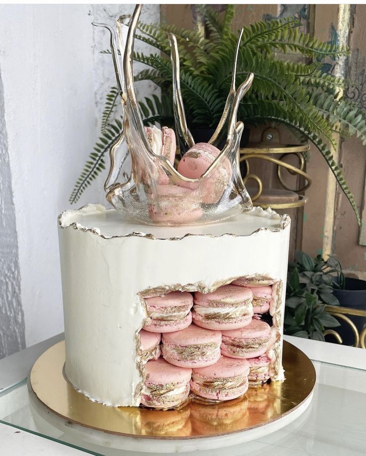 a white cake with pink macaroons on top