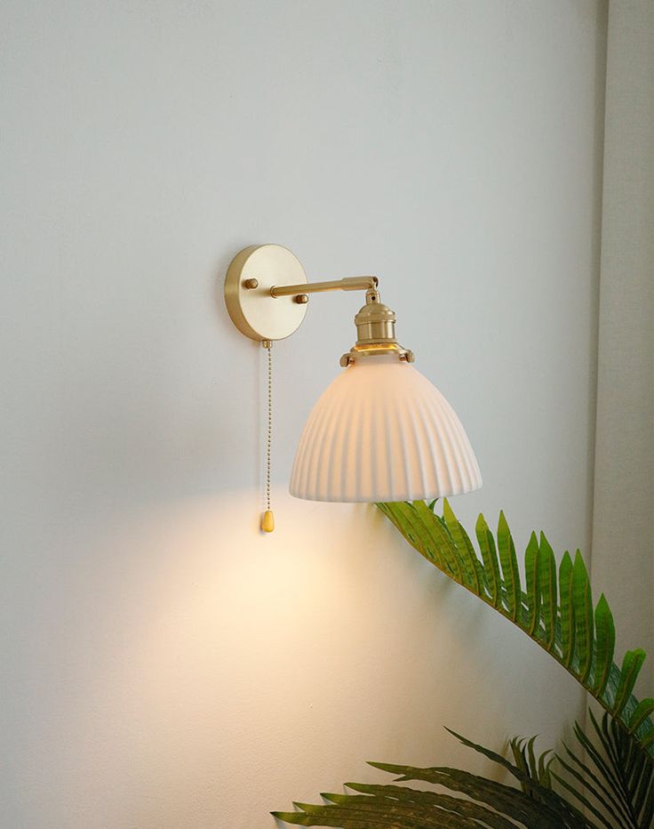 Illuminate your home with elegance and sophistication with our ceramic wall light. With its beautiful ceramic lampshade and brass hardware, our wall light adds an eye-catching touch of style to any room. Our high-quality construction ensures that your light will last for years to come. - Bulb Base - E26/E27 - Voltage 90-240 v - Watts - 60 w - Hardware material - brass - Canopy / wall plate material - brass - Lampshade material - white ceramic - Canopy / wall plate size - 10 cm or 4 inches (12 cm Brass Lampshade, Mid Century Bedside, Lampe Art Deco, Concrete Pendant Light, Ceramic Wall Lights, Bedroom Light Fixtures, Sconces Bedroom, Brass Bathroom, Art Deco Lamps