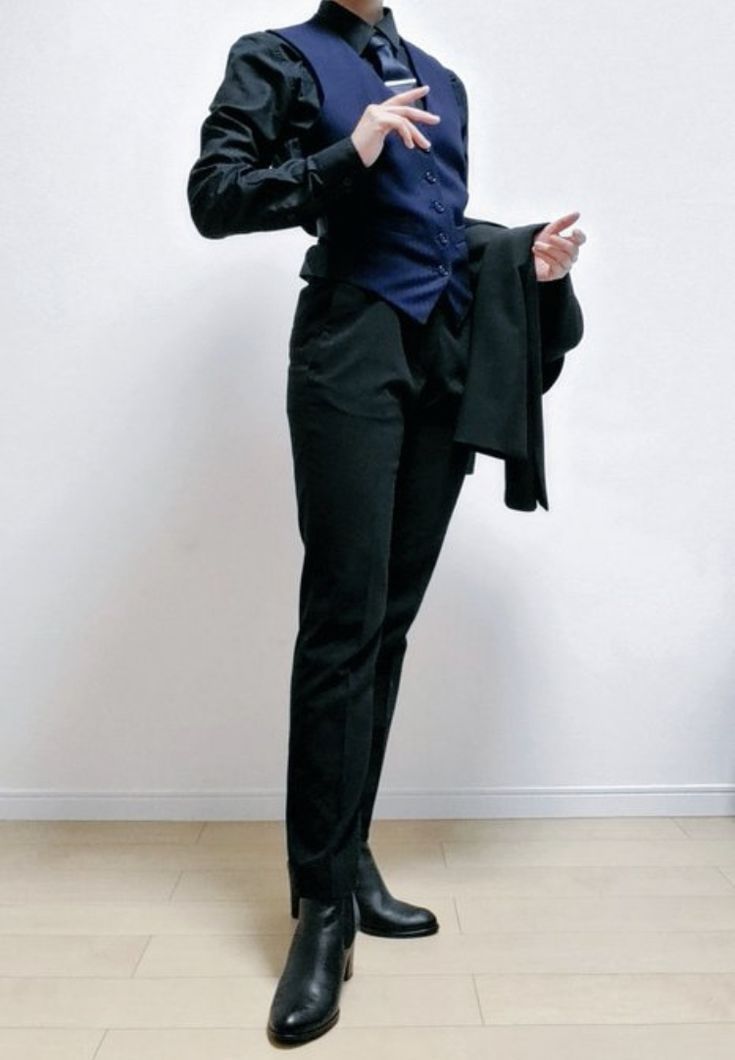 a man in a tuxedo is posing for the camera with his hands on his hips