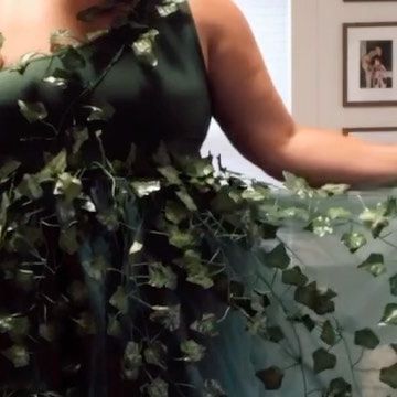 a woman in a green dress with ivy on it