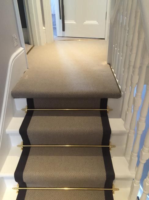 the stairs are lined with beige carpet and gold railings