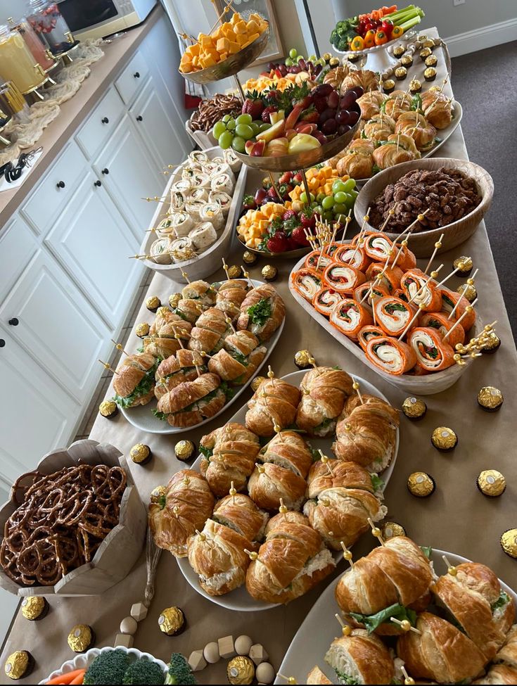 a buffet table filled with lots of different foods and desserts on top of it