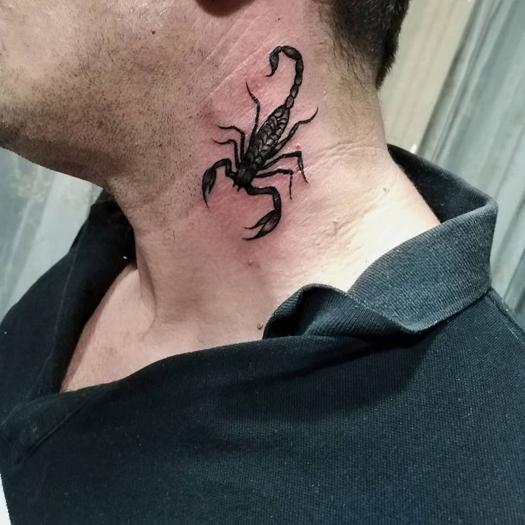 a man's neck with a scorpion tattoo on the back of his neck,