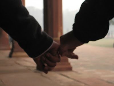 two people holding hands over a stone floor