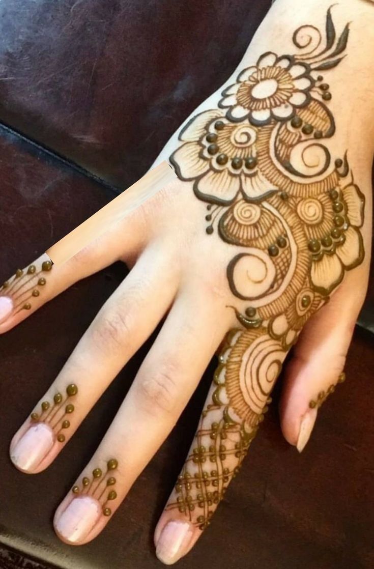 a woman's hand with henna tattoos on it