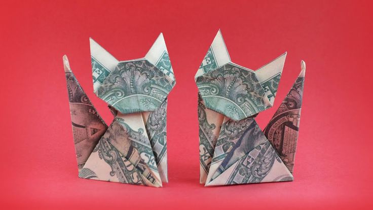 two origami cats made out of money on a red background, one is folded up to look like the other