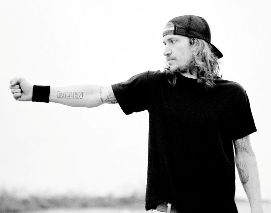 a man with long hair wearing a hat and holding a frisbee in his hand