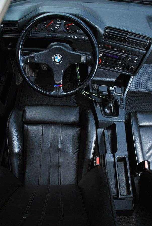 the interior of a car with black leather seats and steering wheel, including an electronic display