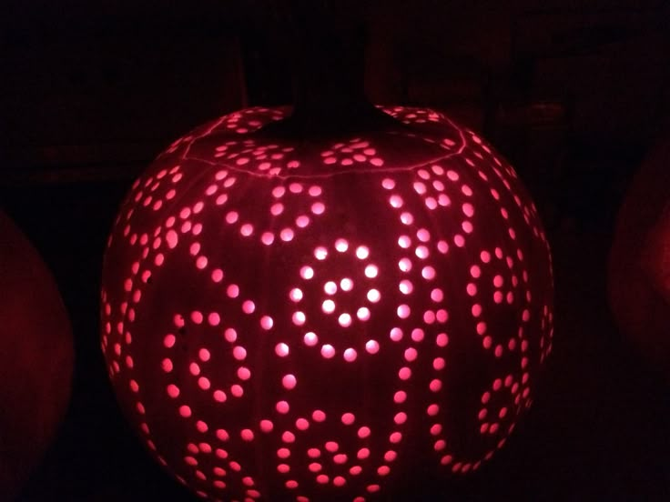 a carved pumpkin with holes on it in the dark