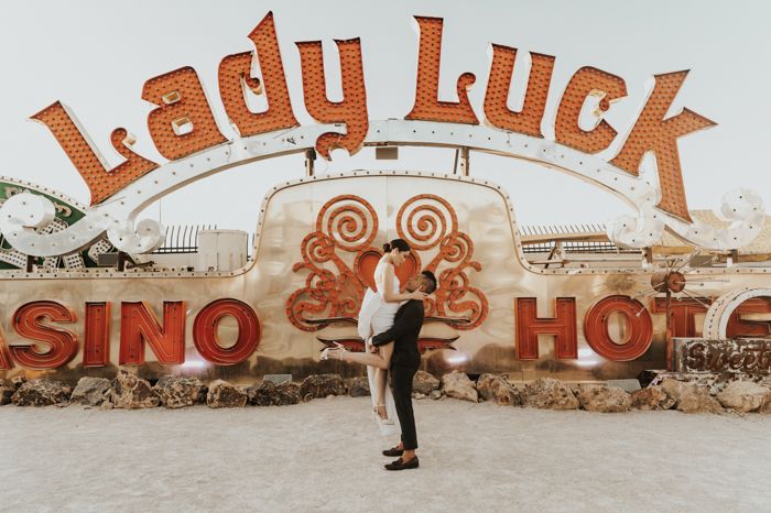 a man standing in front of a sign that says lady luck casino hotel on it