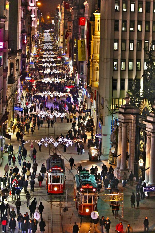 a city street filled with lots of traffic and people walking around it at night time