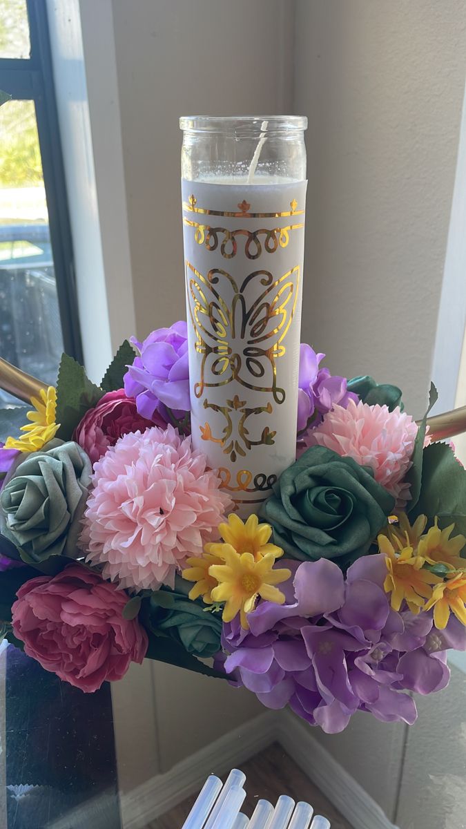 a vase with flowers and a candle in it