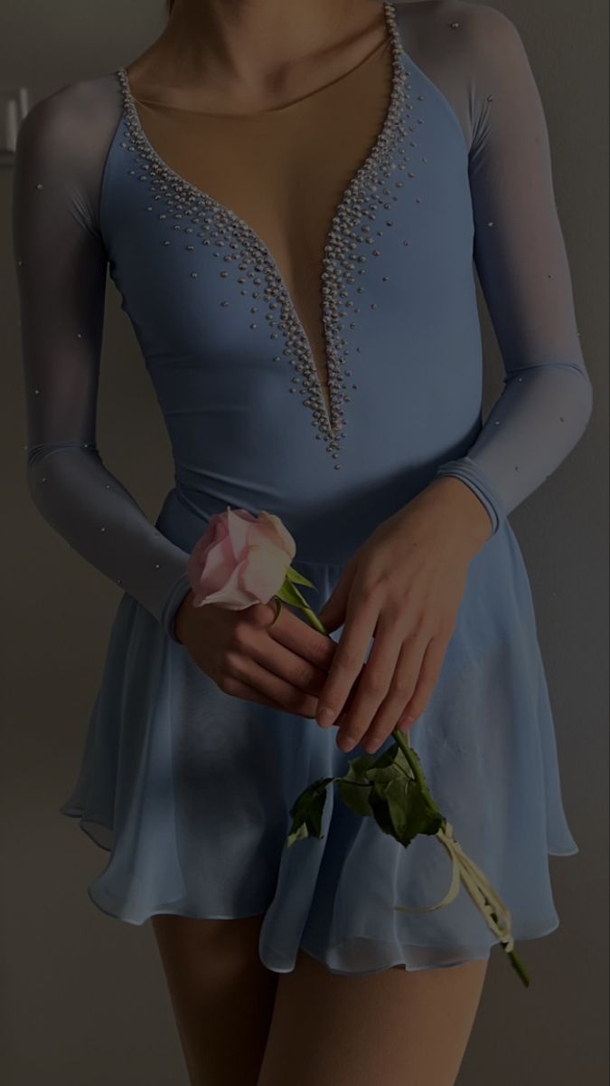 a woman in a blue dress holding a rose