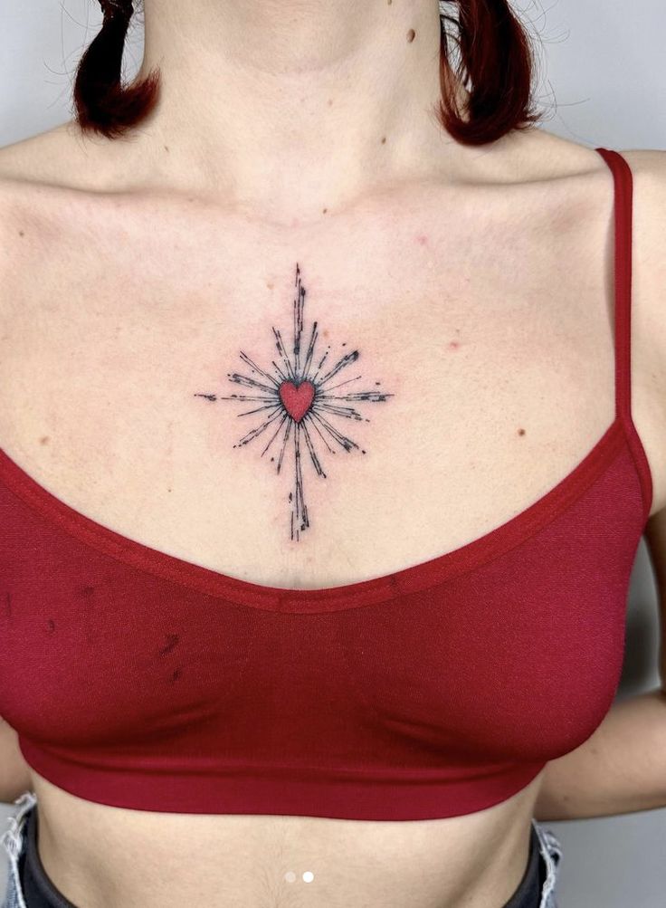 a woman wearing a red top with a heart tattoo on her chest