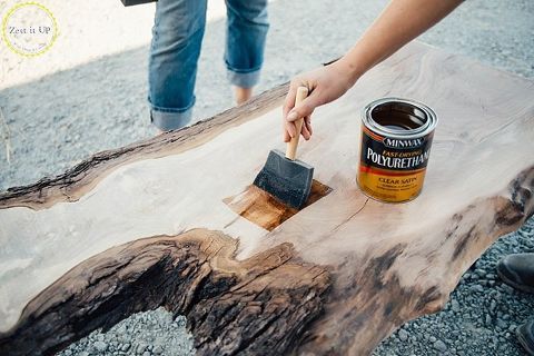 a person painting a piece of wood with a paintbrush