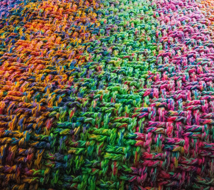 multicolored crocheted blanket laying on top of each other