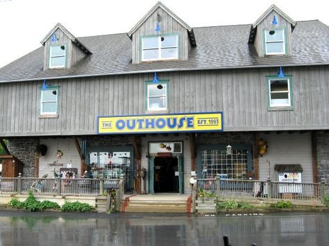 the outside of a building with a sign that says outhouse on it's front