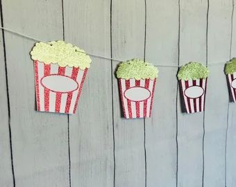 some popcorn boxes are hanging from a string with green and red striped paper on them