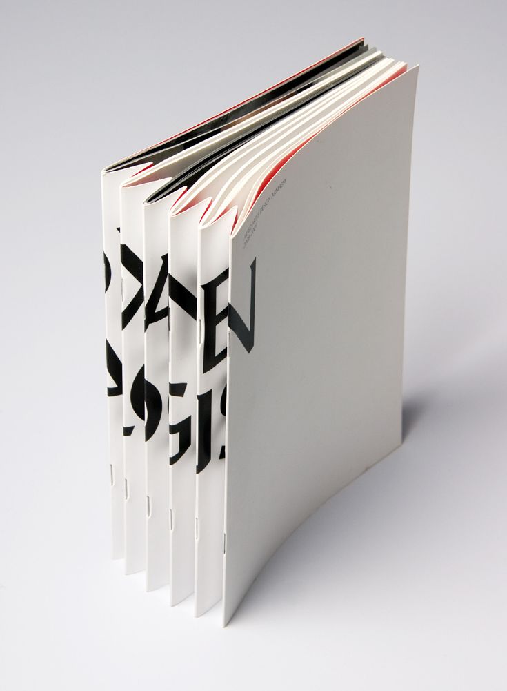 an open book with black and white designs on it's cover, sitting in front of a white background