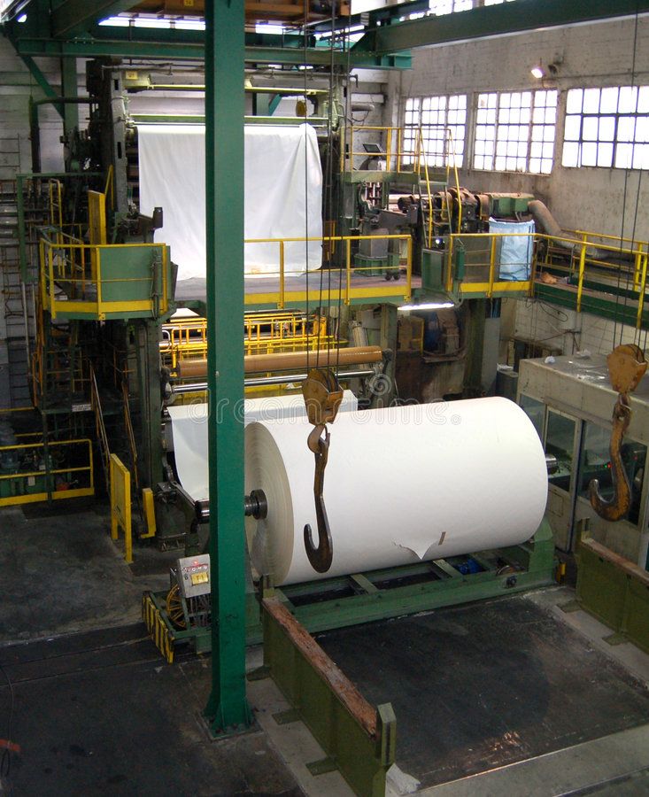 an assembly line with rolls of white paper