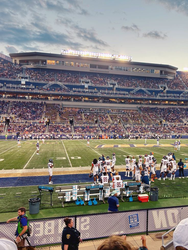 a football game is being played on the field in front of an empty stadium full of people