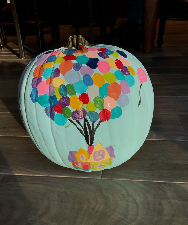 a painted pumpkin sitting on top of a wooden floor