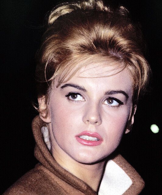 a close up of a person wearing a coat and looking off to the side with a serious look on her face