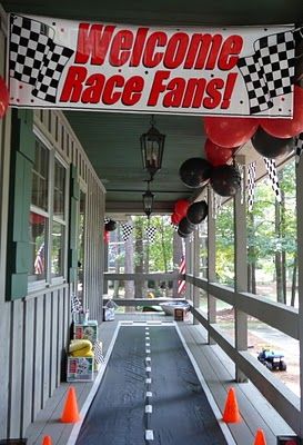 a welcome race fans sign hanging from the side of a building next to an entrance