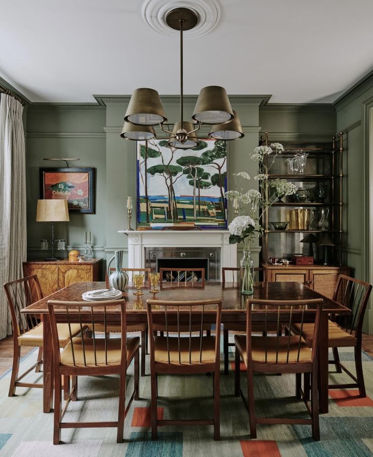 the dining room table is surrounded by wooden chairs and an art work on the wall