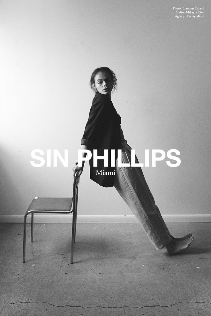 a black and white photo of a woman sitting on a chair with her legs crossed