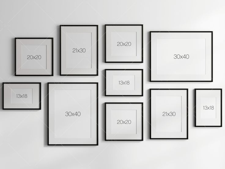 a white wall with black framed pictures on it and numbers in the frames above them