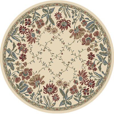 a round rug with flowers and leaves on it in beige, red and blue colors