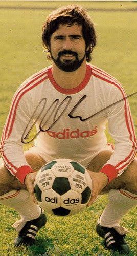 an autographed soccer player holding a ball in front of his face with the name adidas on it