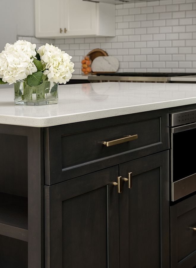 a vase with white flowers sitting on top of a kitchen counter