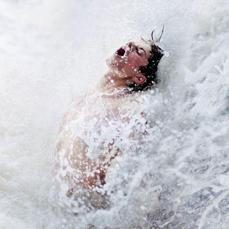 a man swimming in the ocean with his head above the water