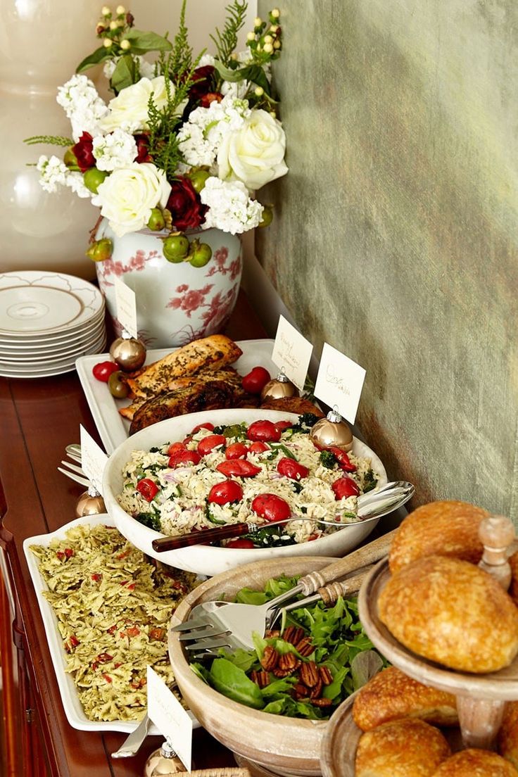 a table filled with lots of food on top of plates and bowls in front of a vase