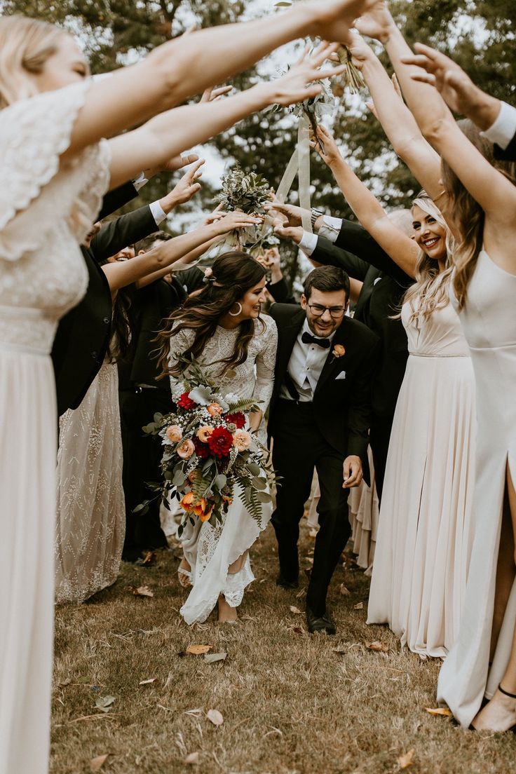 a group of people standing around each other with their arms in the air and holding flowers