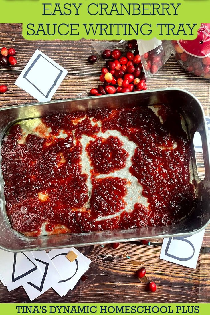 cranberry sauce writing tray on a wooden table with christmas decorations around it and the words, easy cranberry sauce writing tray