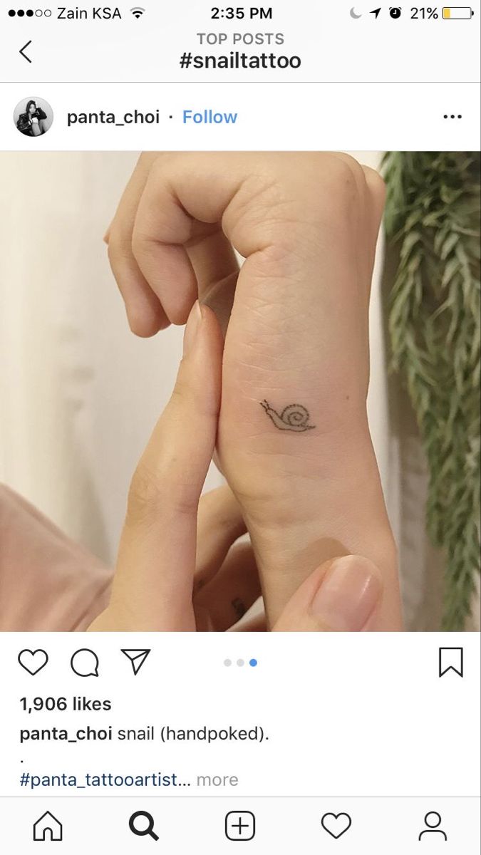 someone is holding their hand with a small tattoo on it