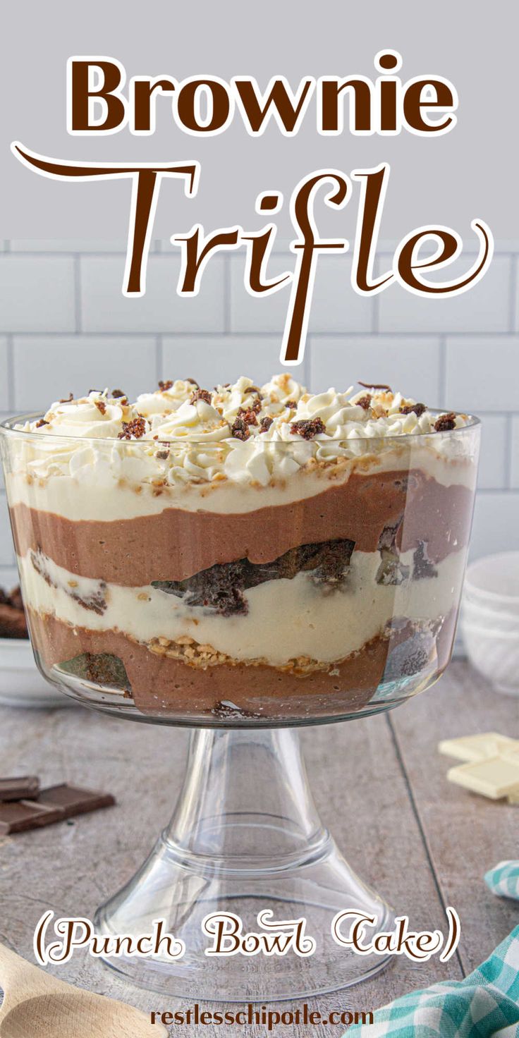 a brownie trifle with white frosting in a glass dish on a table