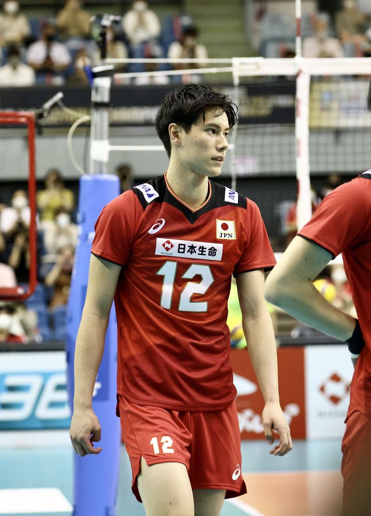 two men in red uniforms are playing volleyball