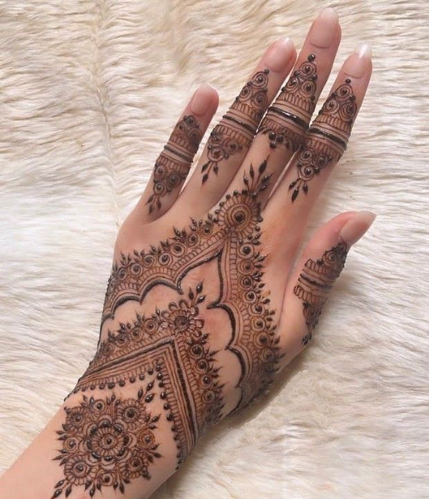 a woman's hand with henna tattoos on it