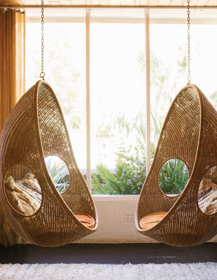 two hanging chairs in front of a window