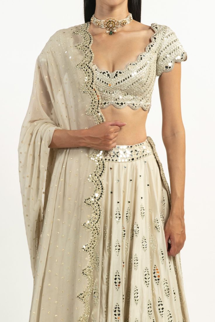 Ivory chanderi lehenga with gota, resham and mirror embroidery. Paired with embroidered blouse and scallop dupatta.
Components:3
Pattern:Embroidered
Type of Work:Gota, Resham, Mirror
Neckline:Scoop
Sleeve Type:Short Sleeves
Fabric:Lehenga-Chanderi , Blouse: Raw Silk, Dupatta: Polka Georgette 
Color:Ivory
Other Details:
Scallop dupatta
Closure:
Lehenga: Side zip
Occasion:Bride, Destination Wedding - Aza Fashions Scallop Dupatta, Chanderi Lehenga, Abhinav Mishra, Mirror Embroidery, Embroidered Lehenga, Silk Dupatta, Bridal Lehenga, Color Ivory, Embroidered Blouse